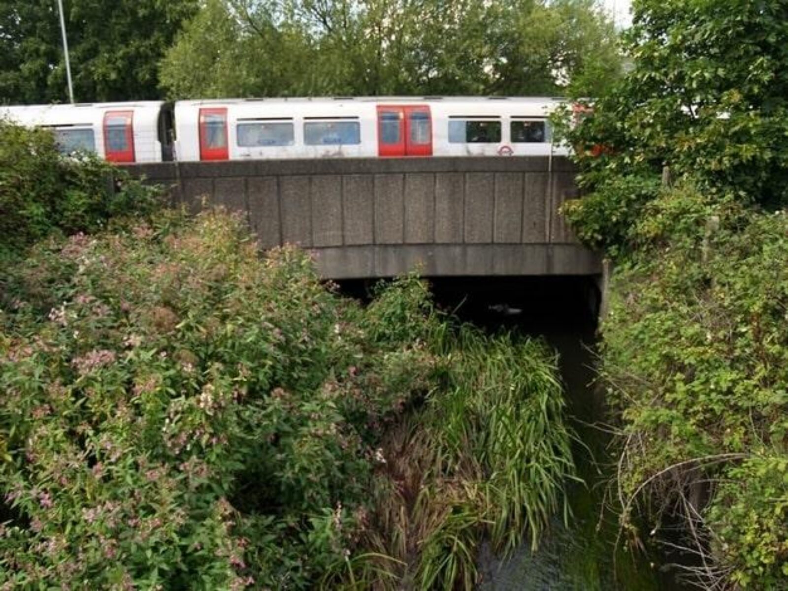 A Piccadilly line train crosses the River Crane at Cranford. Courtesy of londonslostrivers.com