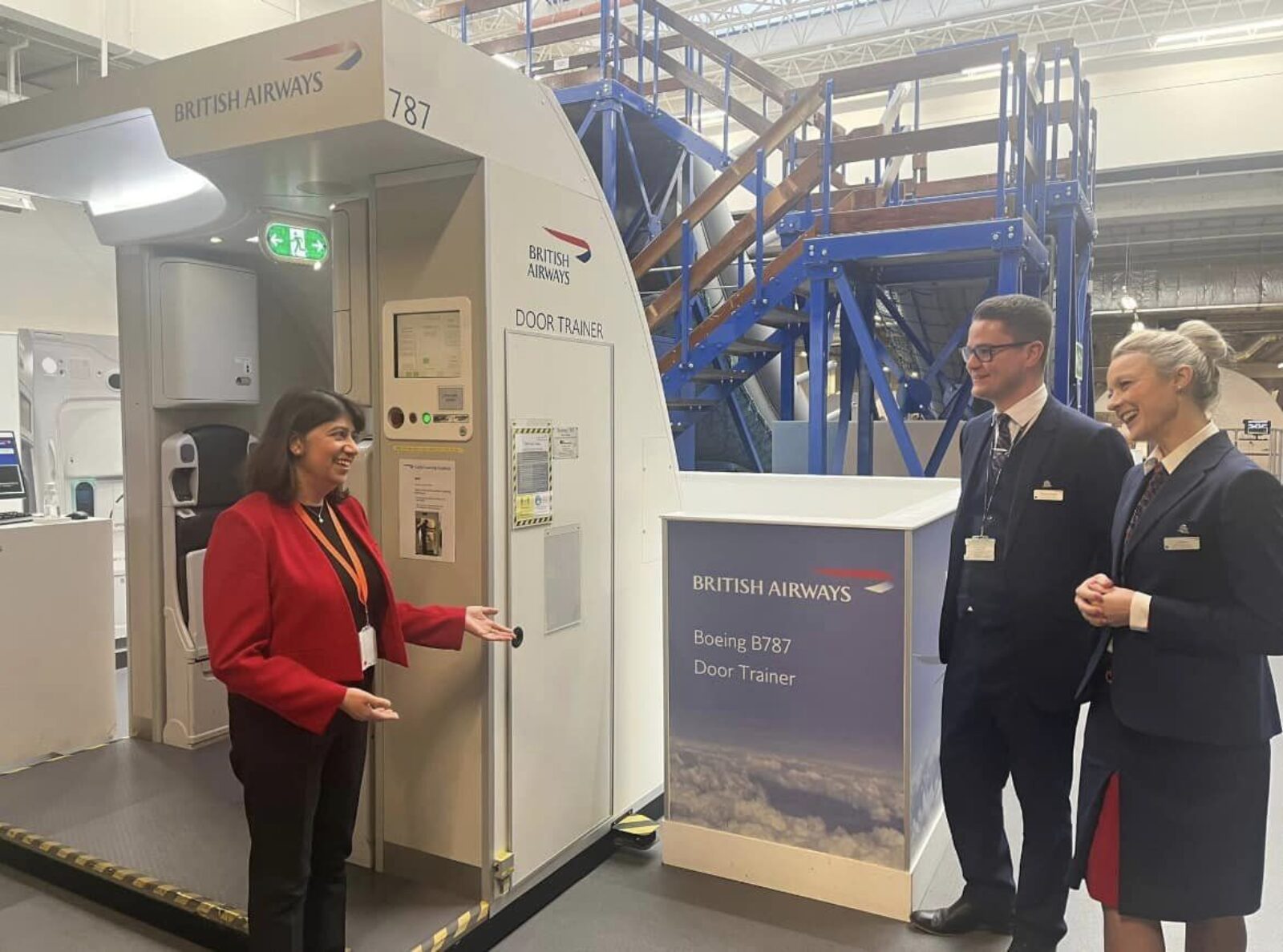 Seema Malhotra MP meets air stewarding trainers in front of a "door trainer", used to show trainees how to operate an aeroplane